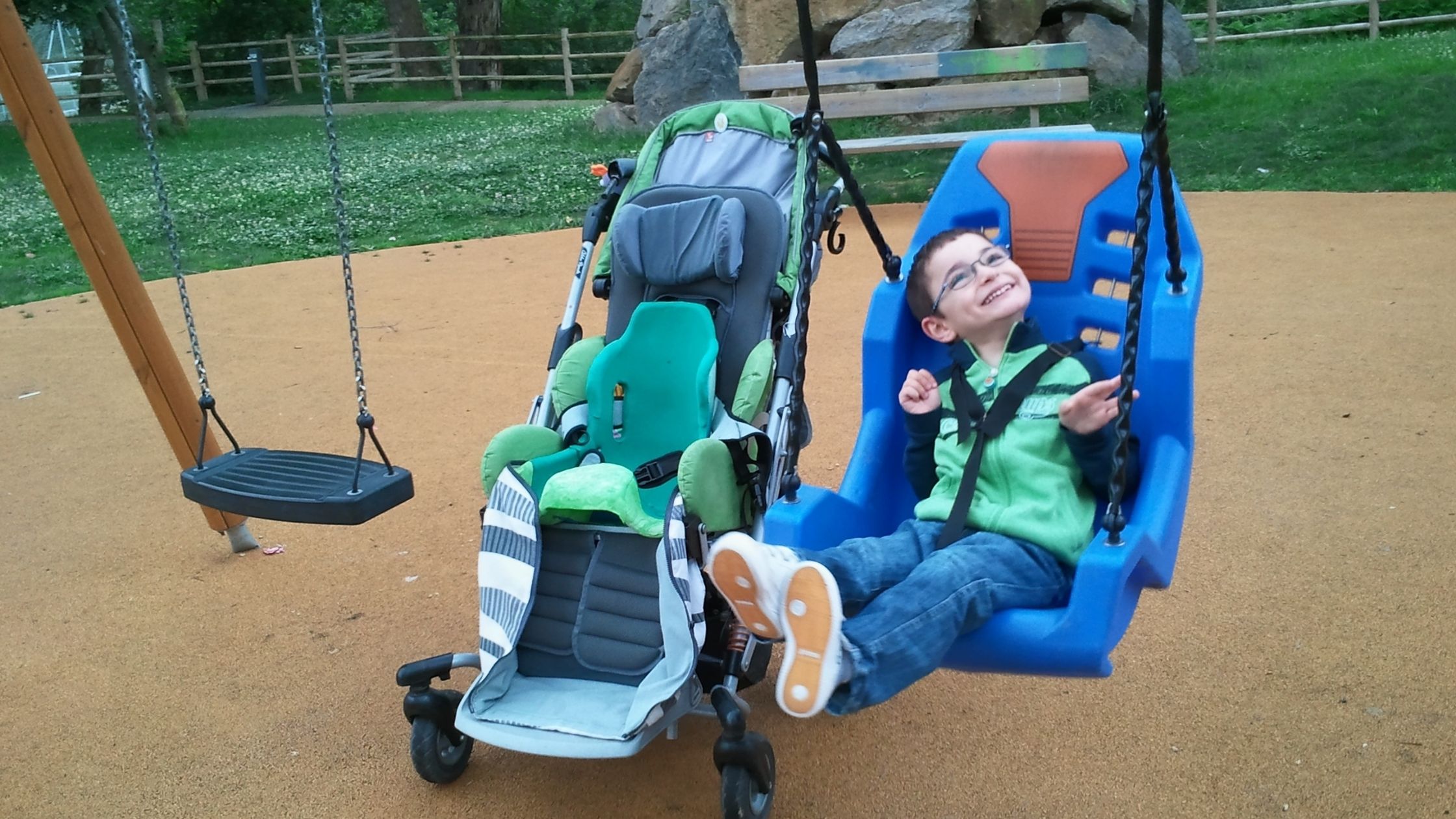 a young boy with assistive chair on a swing