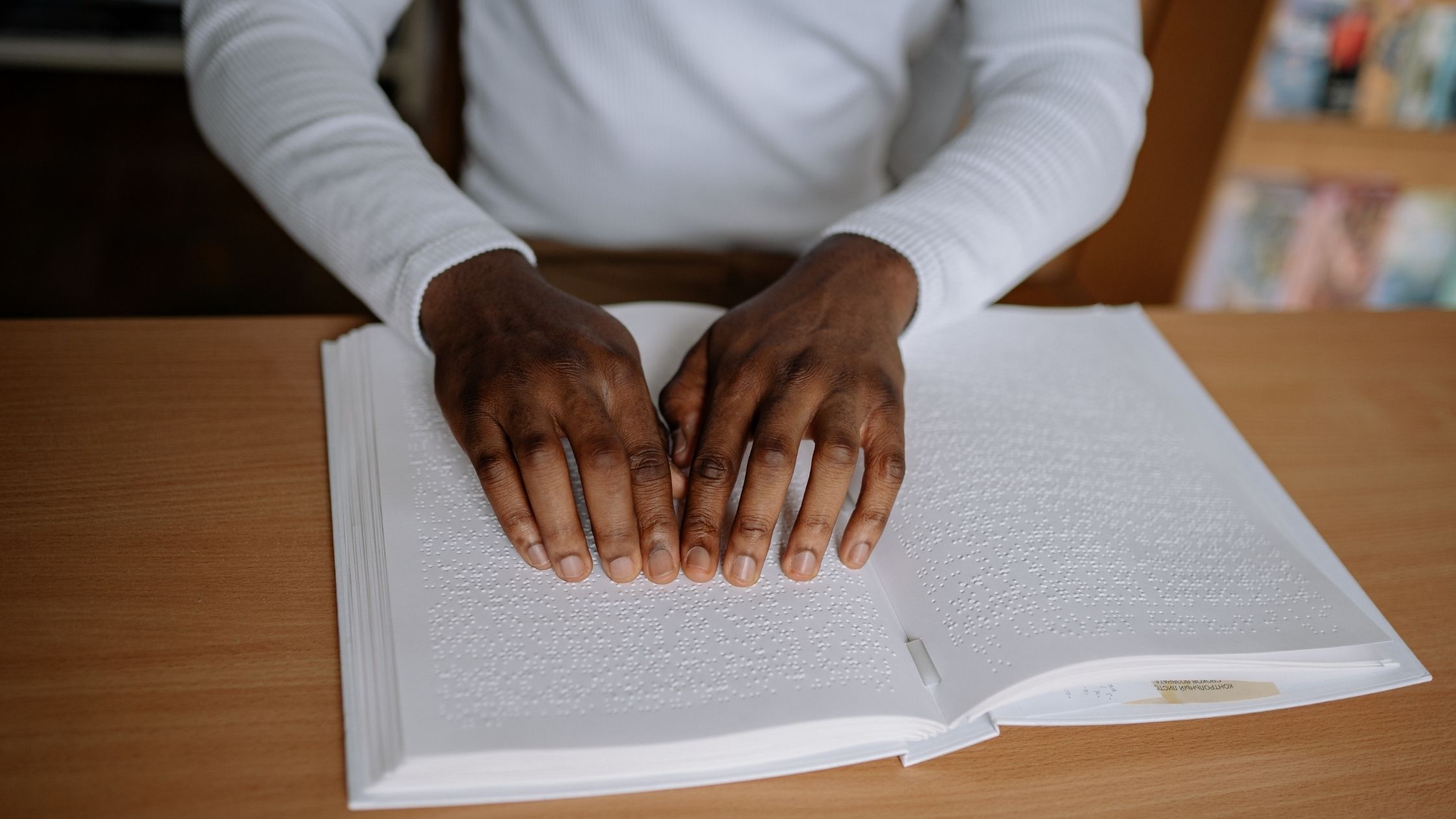 A person reading Braille on a book