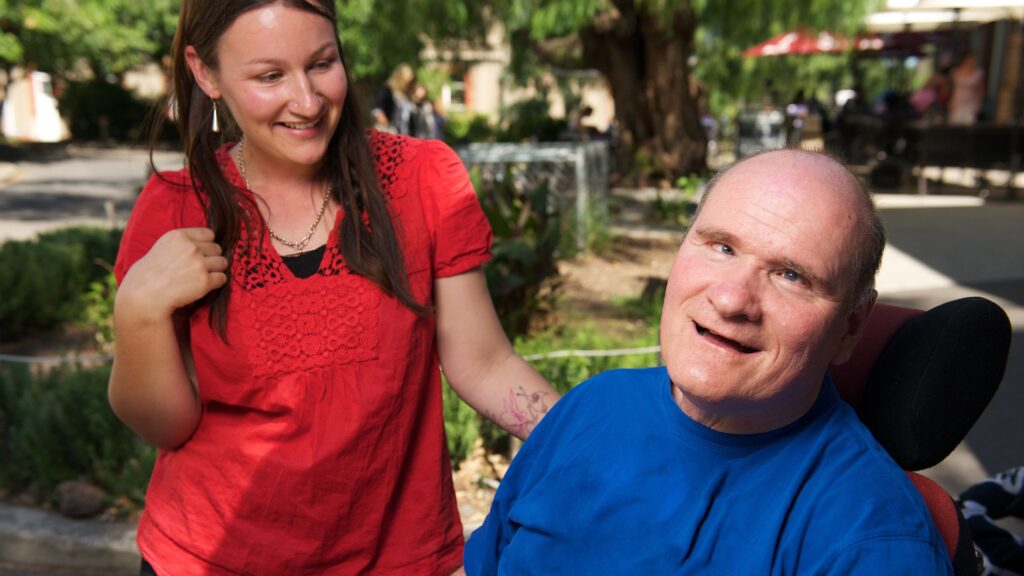 a support worker with a person with disability in his wheelchair