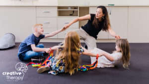 A female dance teacher playing with 3 students