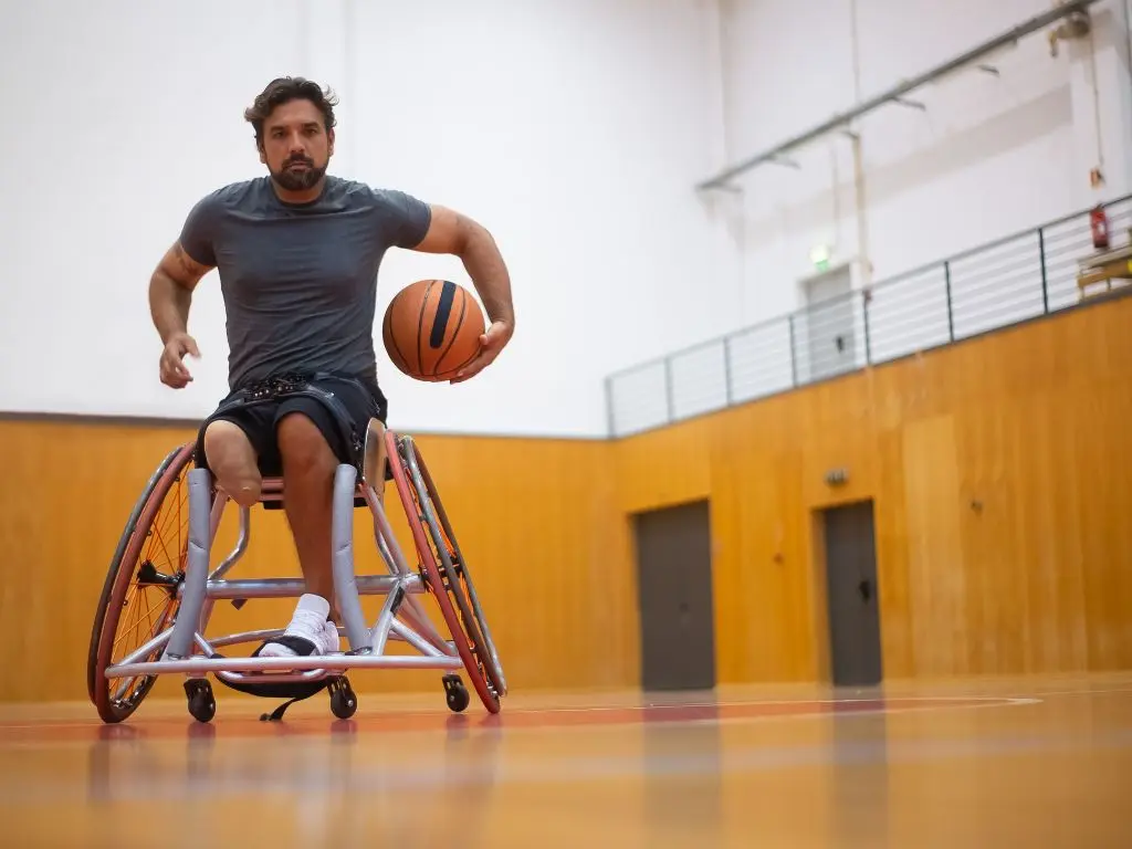 A young man living with disability playing wheelchair basketball